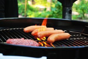 hot dogs and hamburger patty on a grill