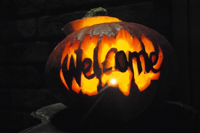 A pumpkin carved into the word welcome.