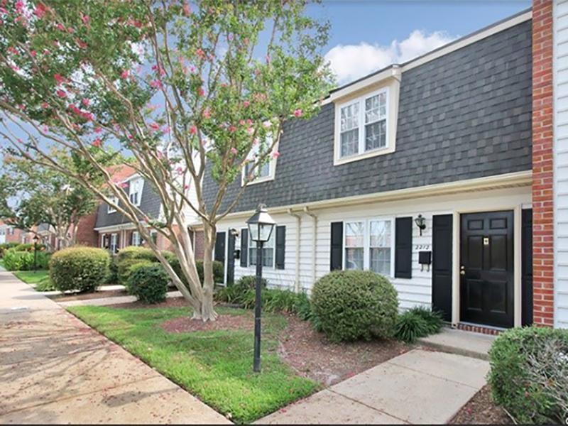 The 2-story buildings at Tech Center Apartments in Newport News are landscaped with trees and flowers.
