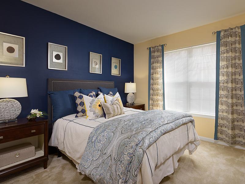 A bedroom at Colton Creek Apartments in McDonough has a bed and 2 nightstands.