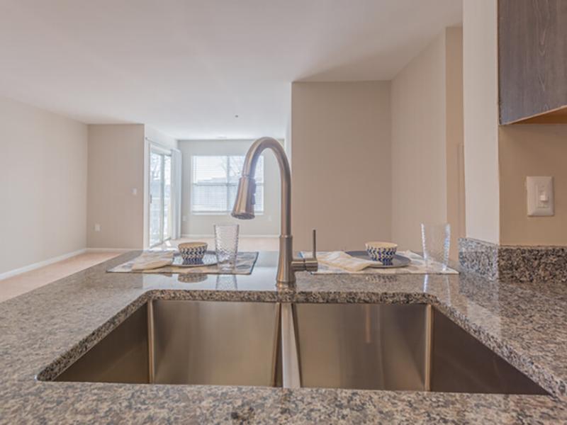 Large stainless steel sink set into a breakfast bar at Bridgewater at Town Center Apartments in Hampton.