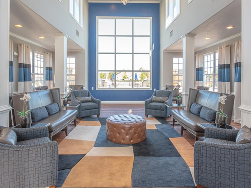 Leather couches and upholstered chairs furnish the lounge at The Lakes at Town Center Apartments.