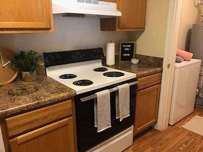 The kitchen has modern appliances and wooden cupboards at Bridgewater at Town Center Apartments in Hampton.