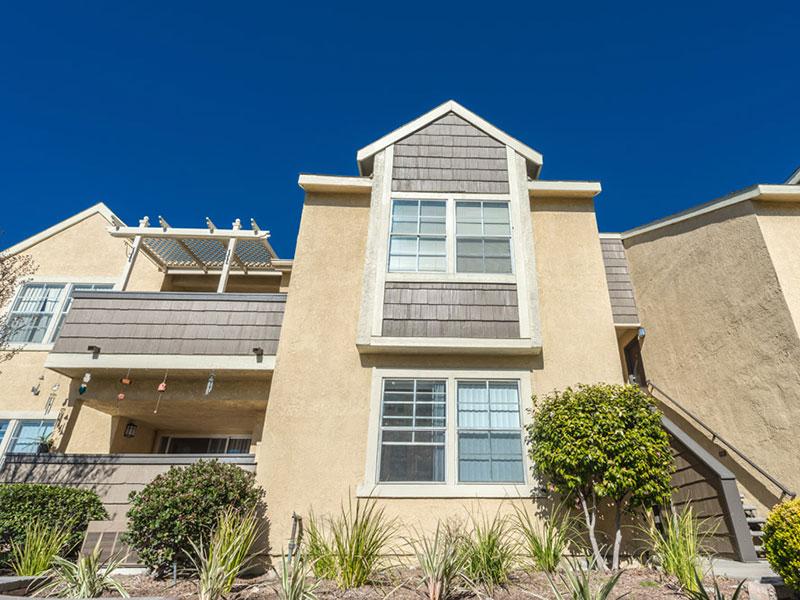 Upland Apartments - Parc Claremont - Exterior of Building with Wood Paneling, Beige Paint, and Balcony/Patio