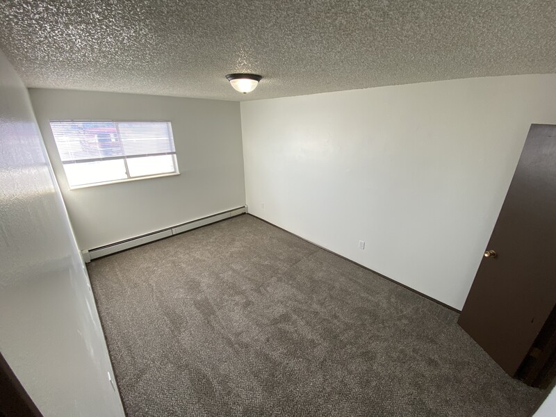 Spacious Carpeted Bedroom | Conquistador Apartments in Casper, WY