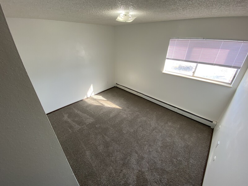 Large Carpeted Bedroom | Conquistador Apartments in Casper, WY