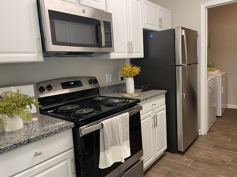 Modern stainless steel appliances and wood-style flooring furnish the kitchen in an apartment in Hampton.